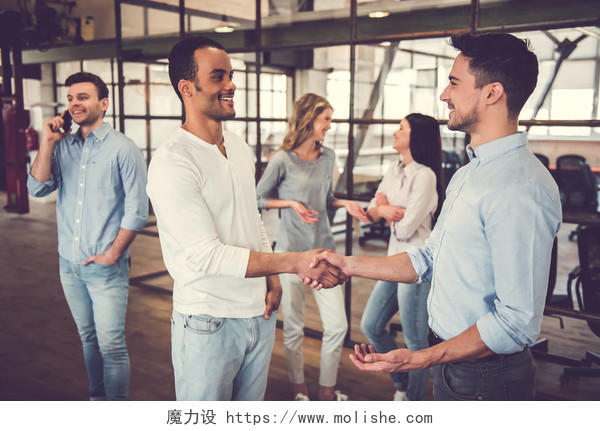 成功的商业人士微笑着站在办公室握手商务人士合作握手成功人士